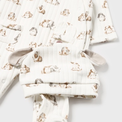 Conjunto de bebé branco com padrão de cães e gorro com orelhas.