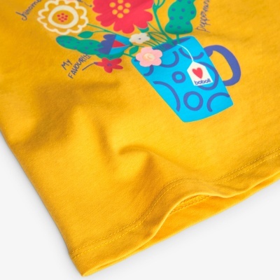 Tecido amarelo com ilustração de jarro azul com flores coloridas e texto 'I love bebok'