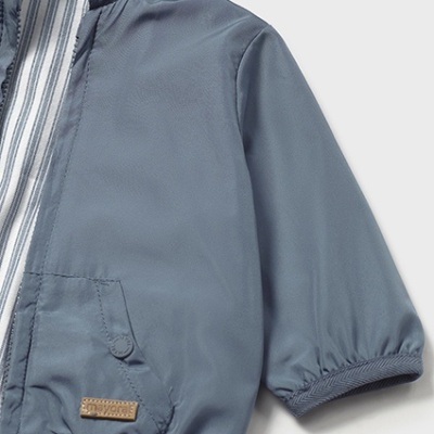 Casaco impermeável cinzento-azulado com capuz riscado azul e branco