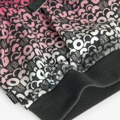 Detalhe de roupa com padrão de letras coloridas e etiqueta 'boboli'