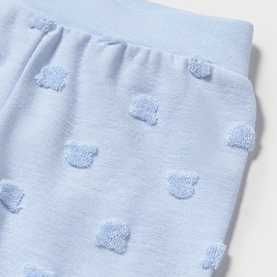 Pormenor de roupa azul claro com bolinhas em relevo e cós canelado