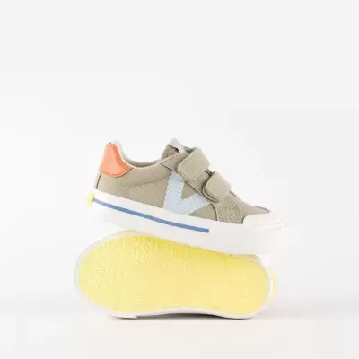 Ténis infantis de lona bege com sola amarela e detalhes em azul e laranja