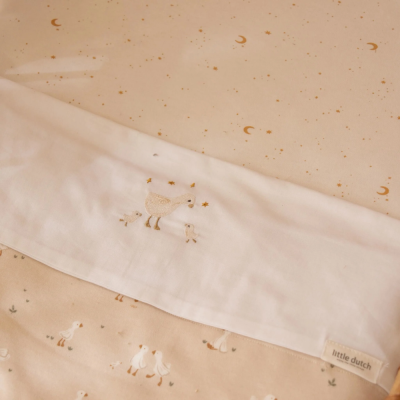 Tecido bege com estrelas douradas e bordados de patos, etiqueta little dutch