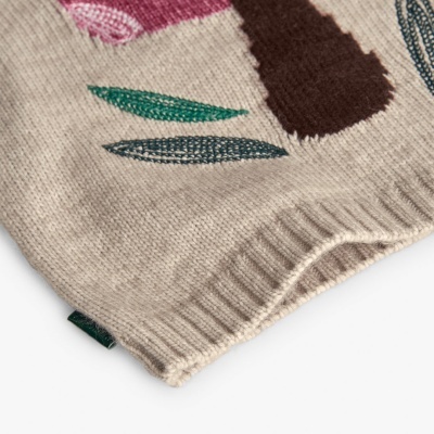 Peça de malha bege com estampa colorida abstrata e bainha canelada.