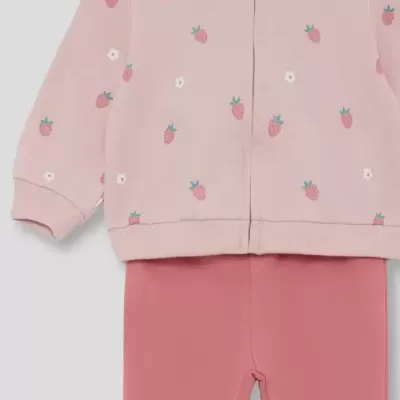 Conjunto de bebé com casaco rosa claro com morangos e leggings rosa.