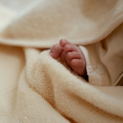 Pés de bebé cobertos por manta bege felpuda