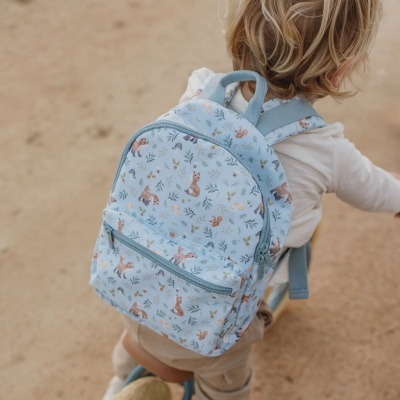 Mochila infantil azul clara com padrão de animais e folhas usada por criança