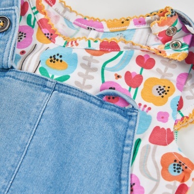 Roupa de bebé com body floral colorido e jardineira azul de ganga