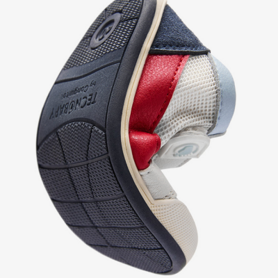 Ténis flexível com sola preta texturada e cores branco, vermelho, azul e bege