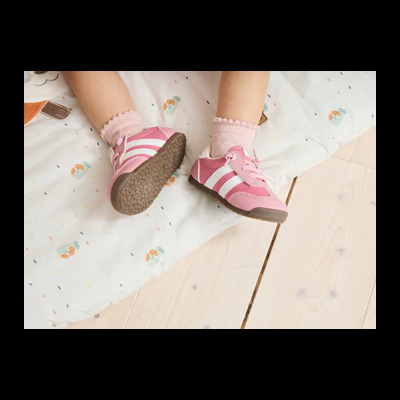 Sapatilhas infantis cor-de-rosa com riscas brancas e meias cor-de-rosa bordadas