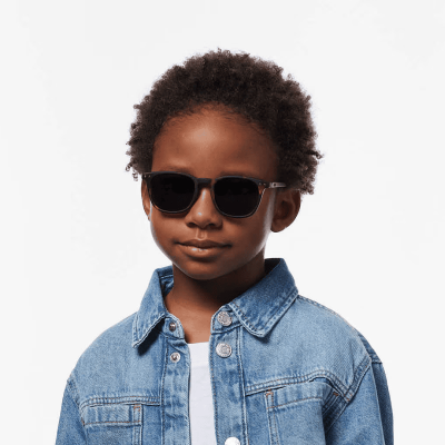 Criança com óculos de sol pretos e casaco de ganga azul claro