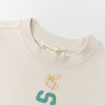 T-shirt off-white com estampa de macaco e letra S verde.