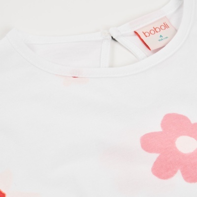 Detalhe vestuário infantil branco com flor rosa e etiqueta boboli