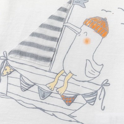 Detalhe de tecido branco com desenho de pato num barco e vela às riscas