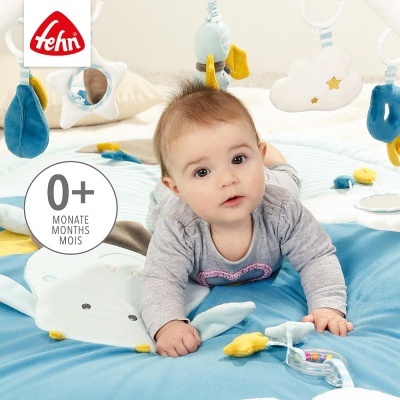 Tapete de atividades para bebés com brinquedos pendurados e bebé a brincar deitado em cima.