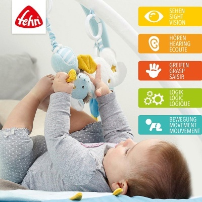 Bebé a brincar com brinquedo de peluche azul e branco suspenso