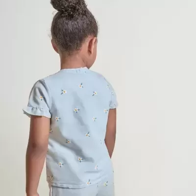 Conjunto infantil azul com flores e folhos, vista de costas.