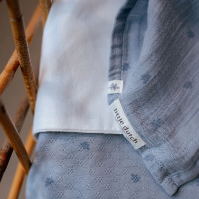 Toalhas ou mantas azuis e brancas com etiquetas 'little dutch' sobre estrutura de madeira