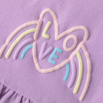 Tecido lilás com estampa em relevo colorida de coração e arco-íris com a palavra LOVE