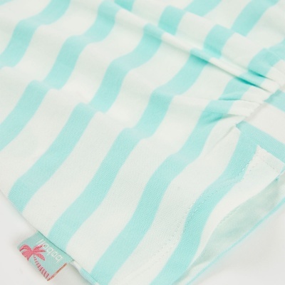 Tecido com riscas azuis claras e brancas e etiqueta com palmeira e texto boboli