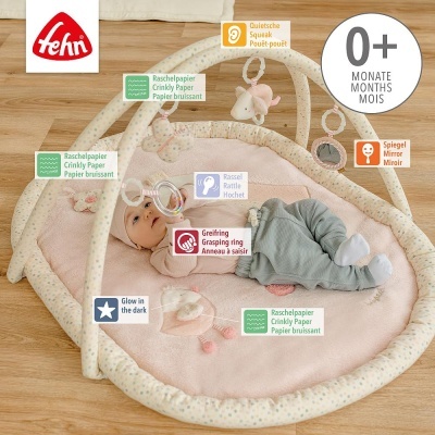 Tapete de atividades para bebé com arco almofadado e brinquedos pendurados em tecido macio rosa.