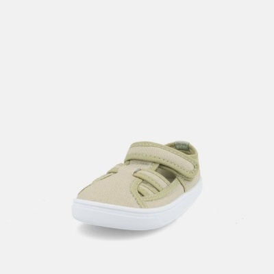 Sapato infantil bege em tecido com sola branca, fecho de velcro e detalhes cortados no topo.