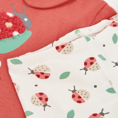 Roupas de bebé com padrão de joaninhas e cor salmão