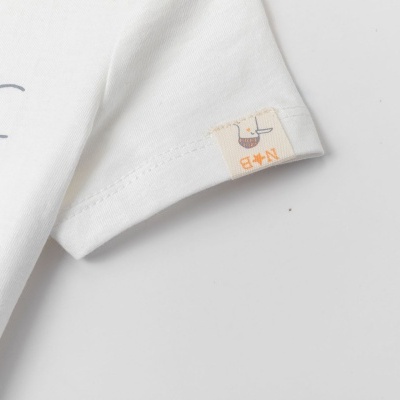 Manga de t-shirt branca com selo costurado com pato e texto N*B.