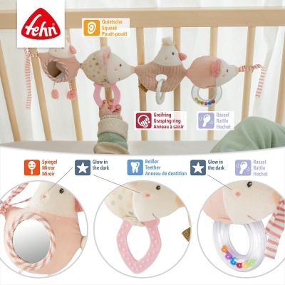 Brinquedo para berço com pássaros de tecido rosa e bege e acessórios como espelho, chocalho e argolas, pendurado em berço de madeira clara