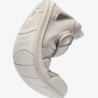 Sapatilha infantil flexível branca com sola de borracha e fecho de velcro.