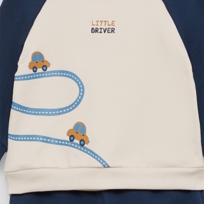 Conjunto de roupa de bebé bege e azul com estampado de carros e texto little driver