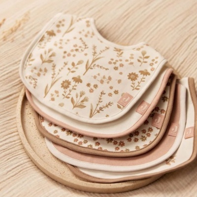 Babetes para bebés com padrões florais suaves e tons pastel