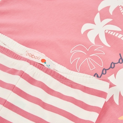 Roupas infantis com camiseta rosa decorada com palmeiras e calças com riscas cor-de-rosa e branco