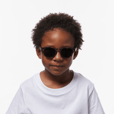 Criança com óculos de sol e t-shirt branca