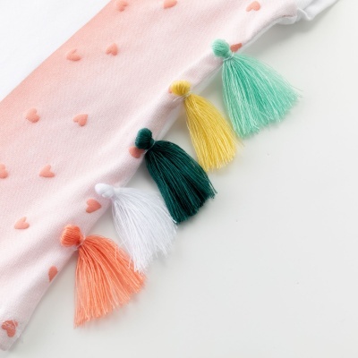 Tecido rosa claro com corações cor de salmão e franjas coloridas