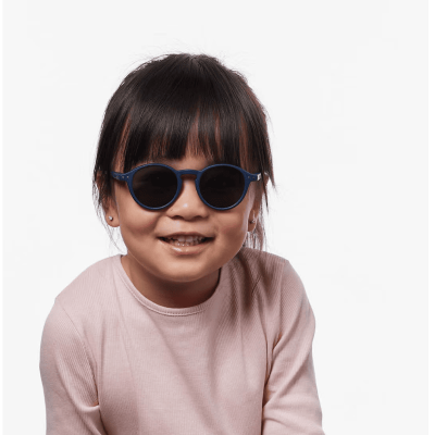Óculos de sol redondos azul escuro em criança com camisa rosa