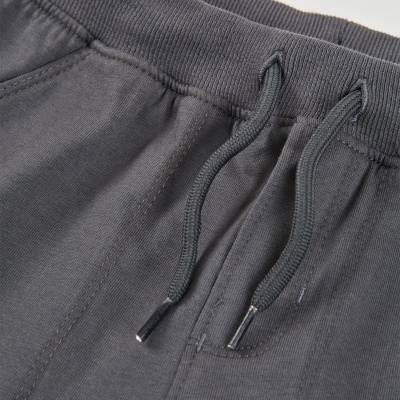 Calças cinzentas com cintura elástica e cordões ajustáveis.
