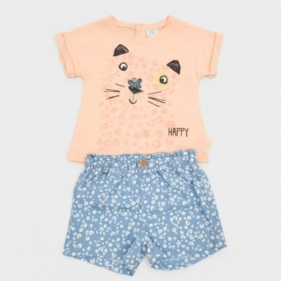 Conjunto infantil de t-shirt pêssego com estampa de gato e calções azuis com padrão branco.