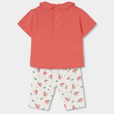 Conjunto de roupa de bebé com t-shirt coral e calças brancas com padrão de joaninhas