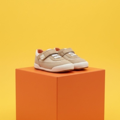 Sapatilhas infantis bege com sola branca e fecho de velcro em cubo laranja