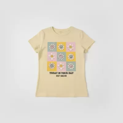 T-shirt bege com estampado de flores sorridentes coloridas e texto motivacional.