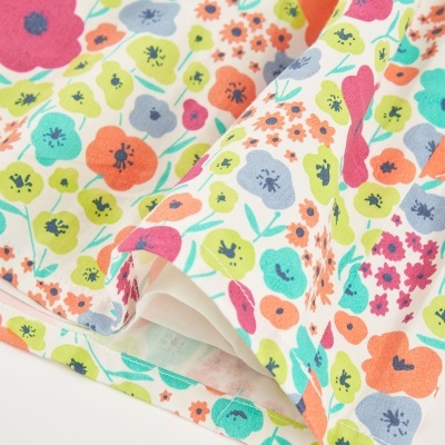 tecido branco com padrão floral colorido e bainha costurada