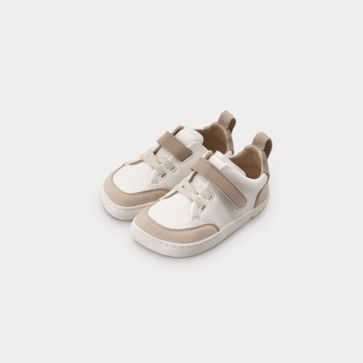 Par de sapatilhas infantis bege e branco com fecho de velcro