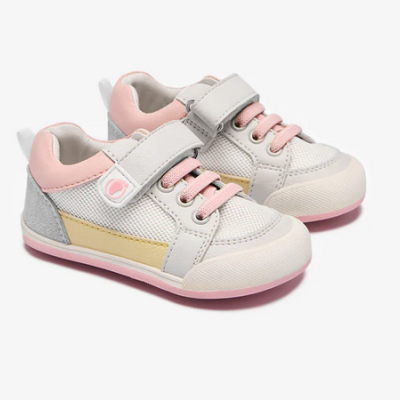 Tênis infantis brancos com detalhes rosa, amarelo e cinza em fundo branco