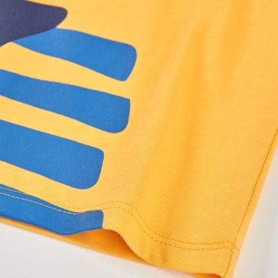 Detalhe da bainha de uma t-shirt amarela com estampa azul