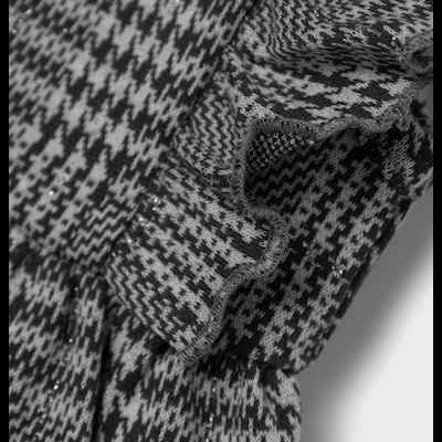 Tecido de malha preto e branco com padrão pied-de-poule e bainha ondulada
