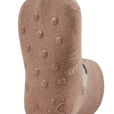 Meia infantil bege com pontos antiderrapantes e letra S no fundo
