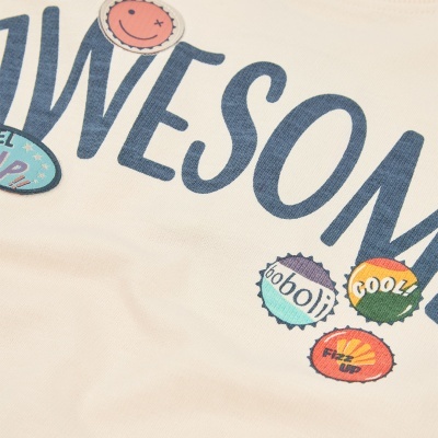 Tecido bege com texto azul e pequenas imagens coloridas tipo tampinhas com texto