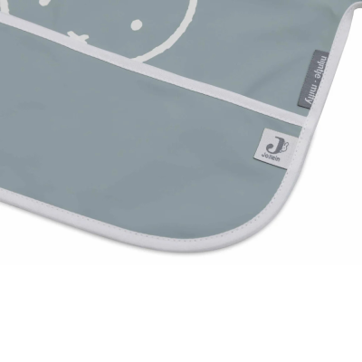 Babete ou toalha impermeável cinza-azulado com linhas e etiquetas visíveis.