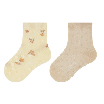 Dois pares de meias de bebé bege e creme com padrões de flores e pontos.
